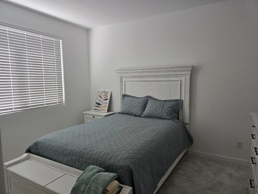 Bright bedroom with queen bed and storage bench