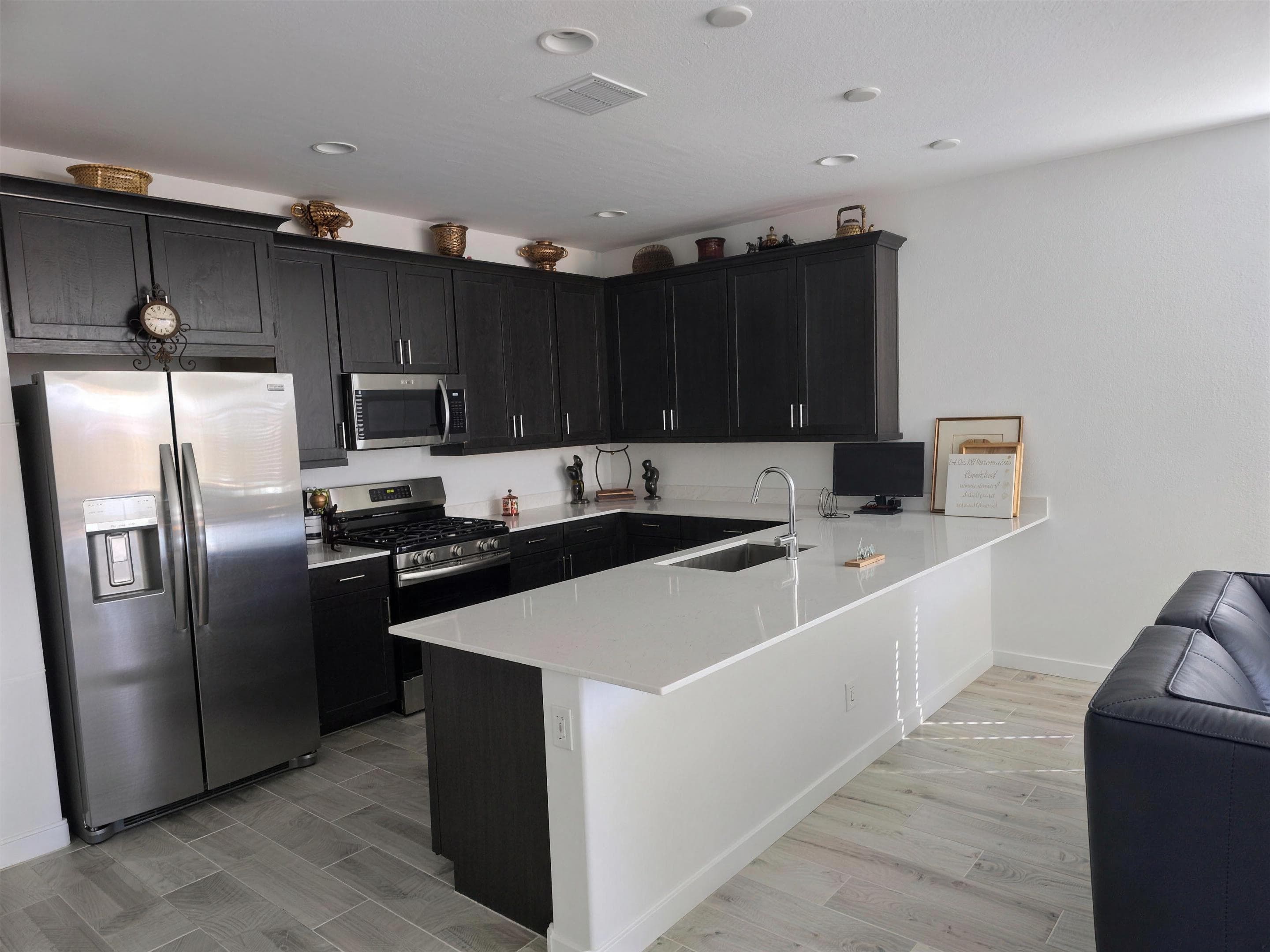 Chef's kitchen with espresso cabinets, quartz island, and stainless appliances